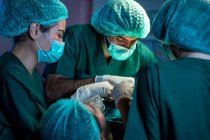 Cirurgiões com assistentes são operados em centro cirúrgico no hospital, equipe médica realizando operação. — Fotografia de Stock