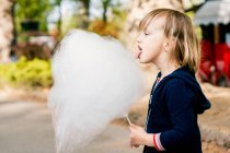 Menina bonito 3-4 anos de idade comendo algodão doce — Fotografia de Stock