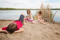Niños jugando junto a un lago - foto de stock