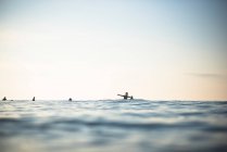 Азиатка развлекается в составе команды серфинга ранним летним утром — стоковое фото