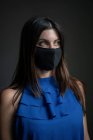 Retrato interior de uma mulher branca atraente usando uma máscara facial — Fotografia de Stock