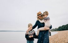 Mom and her kids enjoying a walk together on the beach in England — Stock Photo