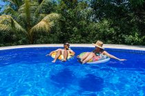Счастливая пара с надувными кольцами в бассейне — стоковое фото