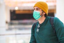 Modern spanish man with green protective mask in shopping mall — Stock Photo