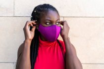 Mujer africana atleta poniéndose la máscara - foto de stock