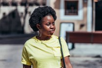 Porträt eines afroamerikanischen Mädchens, das eine Straße in der Altstadt entlang geht. — Stockfoto