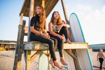 Zwei Freundinnen, die im Sommer bei Sonnenaufgang surfen — Stockfoto
