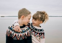 Irmão e irmã abraçando e sorrindo juntos na praia no Reino Unido — Fotografia de Stock