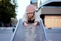 Niña de 4 años en el parque de skate sonriendo con un casco - foto de stock