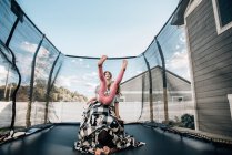 Sorelle che saltano su un trampolino nel cortile con il padre — Foto stock