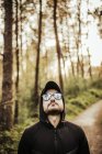 Man with sunglasses and hood in a beautiful forest — Stock Photo