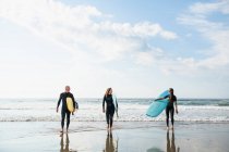 Grupo de amigos surfistas durante um surfe de verão — Fotografia de Stock