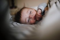 Brun chevelu sommeil bébé garçon paisiblement co-sommeil — Photo de stock