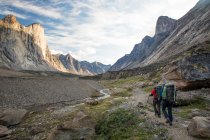 Excursionistas en Akshayak Pass, lugar de viaje en el fondo - foto de stock