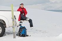 Жінка сидить на спині пікапа, роблячи перерву на лижах — стокове фото