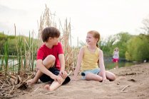 Діти грають на піску біля озера — стокове фото
