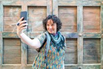 Moderne Frau mittleren Alters macht ein Foto von ihrem Smartphone — Stockfoto