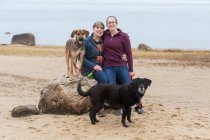 Portrait of same sex female couple with two dogs on Cape Cod beach — Stock Photo