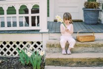 Маленька дівчинка з букетом квітів у парку. — стокове фото