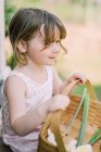Kleines Mädchen mit einem Korb voller Blumen — Stockfoto