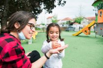 Bambina ispanica che gioca con sua madre nel parco — Foto stock