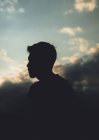 Silhouette of man between clouds — Stock Photo