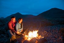 Couple assis près du feu de camp en Islande — Photo de stock
