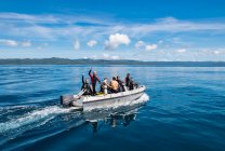 Buceadores se dirigen a punto de buceo en bote bote en Raja Ampat - foto de stock