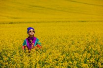Stylish girl in 90s tracksuit in rapeseed field — Stock Photo