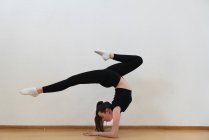 Femme pratiquant handstand dans la salle de gym — Photo de stock