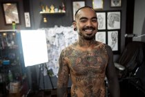 Татуировщик все в татуировках играет на гитаре и поет в тату — стоковое фото
