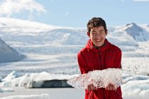 Adolescent garçon tenant jusqu'à glace de glacier lagune en Islande — Photo de stock