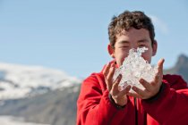 Ragazzo adolescente che regge il ghiaccio dalla laguna dei ghiacciai in Islanda — Foto stock