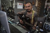 Tattoo guy all in tattoos plays the guitar and sings in the tatt — Stock Photo