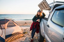 Jovem mulher com xícara beber café na praia — Fotografia de Stock
