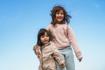 Две девушки на фоне голубого неба — стоковое фото