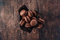 Biscoitos de macarons de chocolate em um fundo de madeira — Fotografia de Stock
