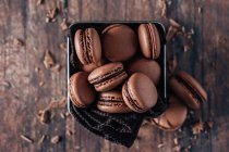 Galletas de chocolate macarons sobre un fondo de madera - foto de stock