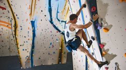 Man climbing at indoor climbing wall in London — Stock Photo