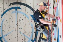 Man setting climbing routes at indoor climbing centre — Stock Photo