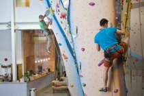 Man climbing at indoor climbing wall in London — Stock Photo