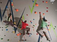 Three climbers bouldering at indoor climbing wall in London — Stock Photo