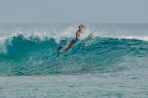 Femme surfeuse dans l'océan Indien, Maldives — Photo de stock