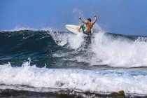 Uomo con tavola da surf surf sull'onda del mare contro il cielo limpido — Foto stock