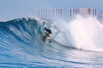 Homme avec planche de surf surf sur mer vague contre ciel clair Homme avec planche de surf surf sur mer vague contre ciel clair — Photo de stock