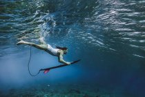 Surfer mit Surfbrett beim Tauchen unter Wasser auf den Malediven — Stockfoto