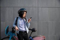 Молода людина дивиться на мобільний телефон з прокатом міського велосипеда — стокове фото