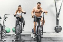 Couple doing bike in the gym, crossfit — Stock Photo