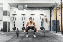 Femme avec haltères dans la salle de gym faire crossfit — Photo de stock