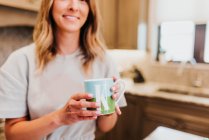 Mujer joven con taza de té en casa - foto de stock
